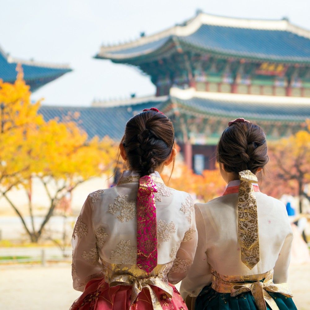 Two visitors wearing hanbok at a Korean palace